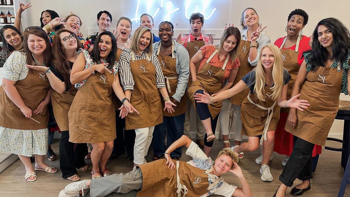 A large group posing for a photo after a candle making session.