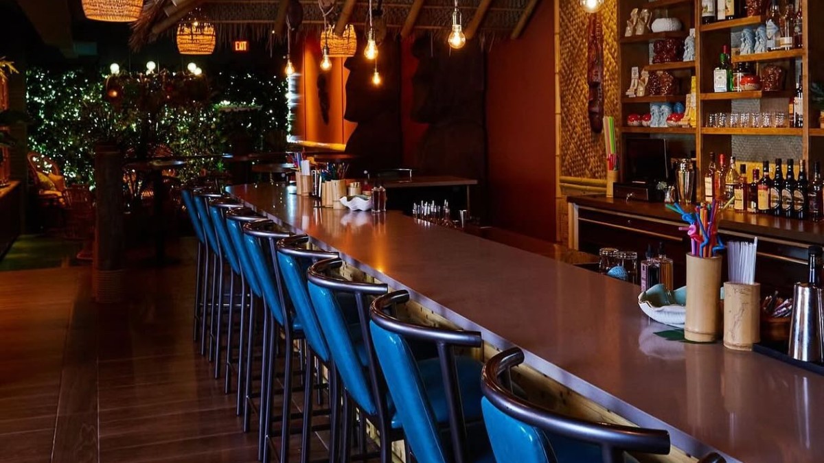 A tropical style bar with mood lighting.