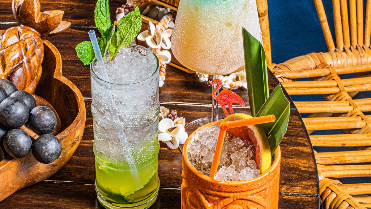 Multiple tropical-themed cocktails on a table.
