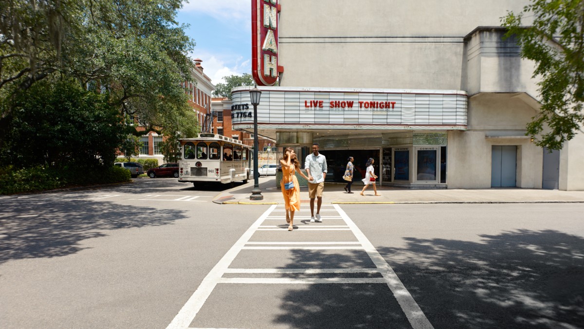 A young couple walking away from the Savannah Theatre in Savannah, GA.