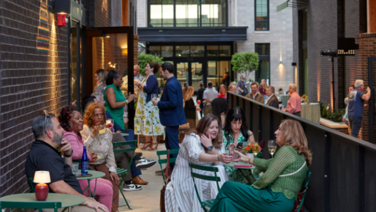 A group of people socializing in an outdoor patio.