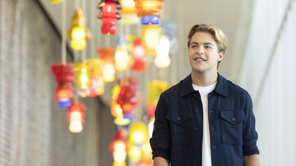 A young student walking through an art gallery.