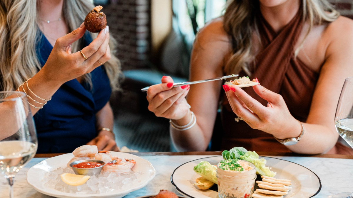 Two women dining and laughing together over brunch.