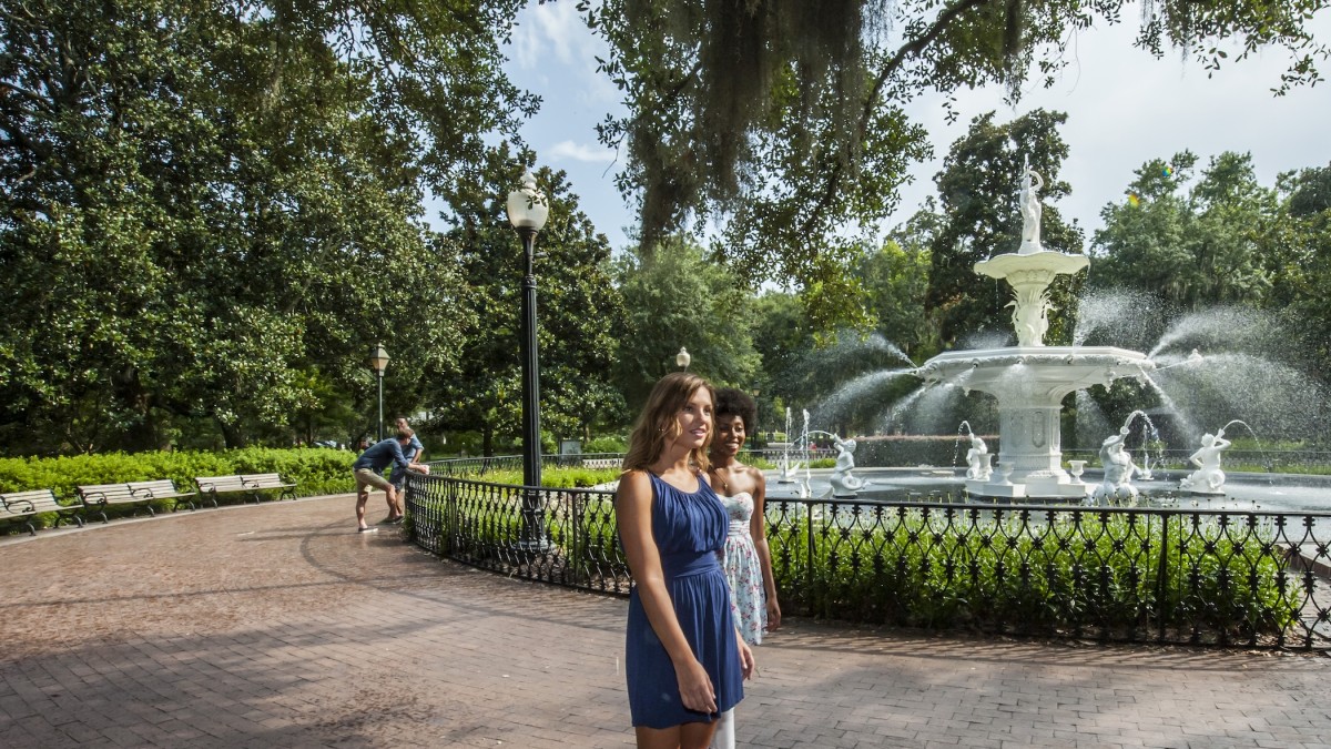 Two friends walking past the iconic Forsyth Park Fountain in Savannah, GA.