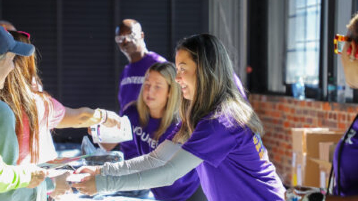 woman handing race bib