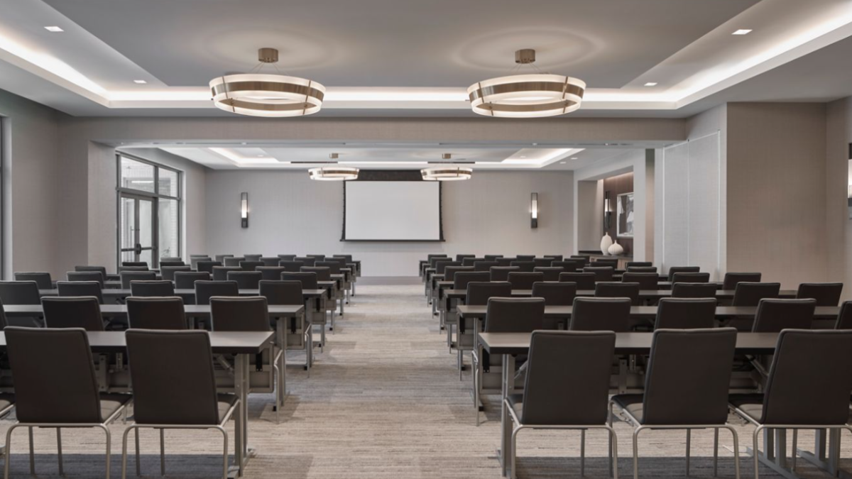 Classroom-style meeting room at AC Hotel Savannah featuring modern design, neutral décor and flexible seating.