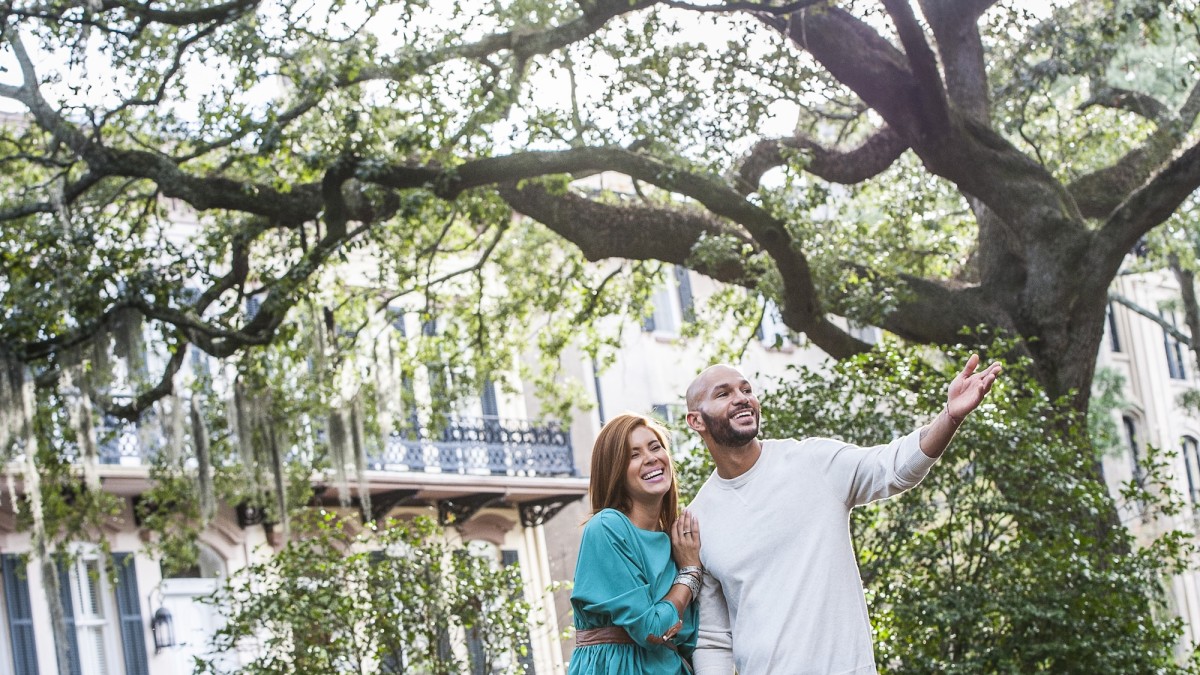 A couple strolling through Monterey Square in Savannah, GA.