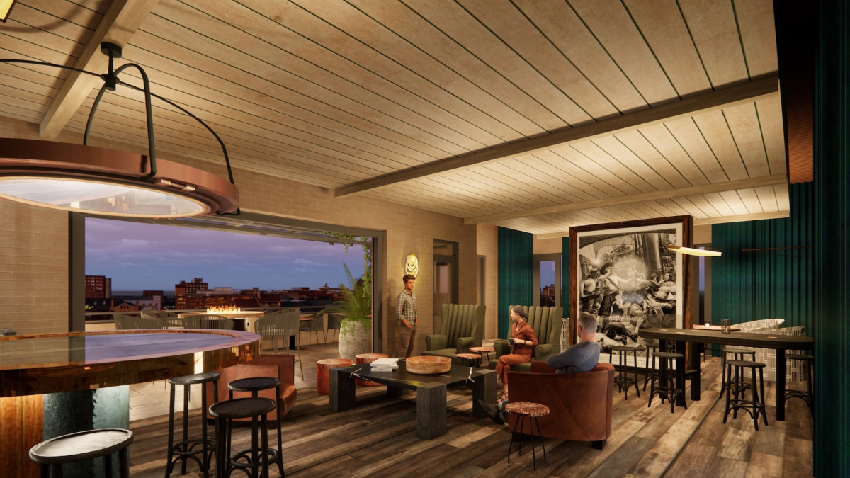 Waving Girl Rooftop lounge at Tempo by Hilton Savannah Historic District, featuring indoor-outdoor seating, a bar area and city views at dusk.