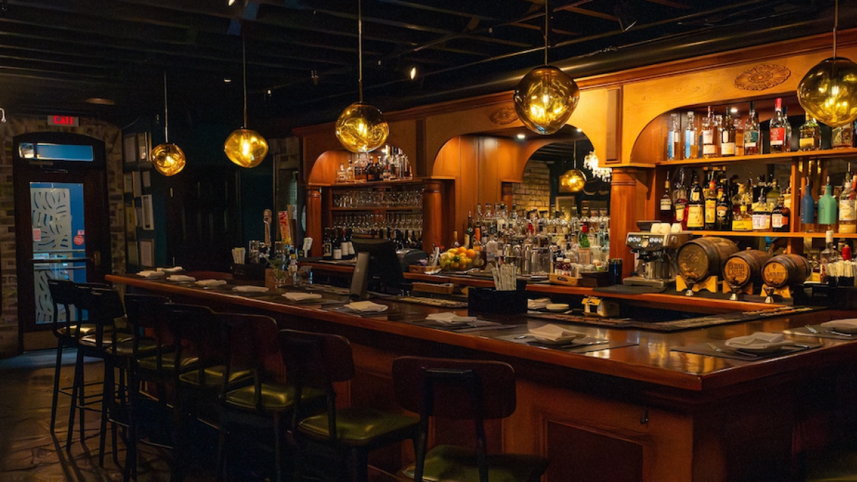 Moody interior of Alligator Soul featuring a wood bar, hanging pendant lights and shelves of spirits.