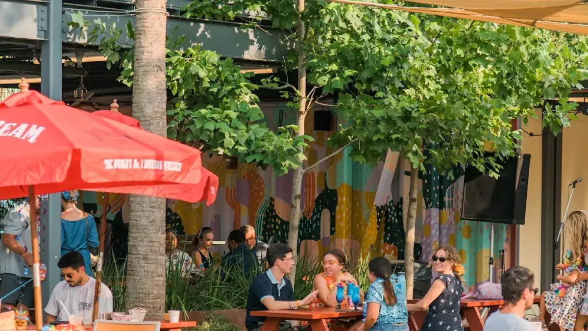 People gathering at picnic tables in the outdoor courtyard at Starland Yard.