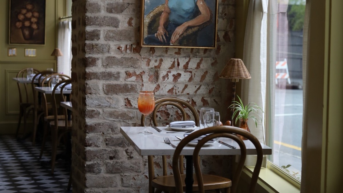 Interior of Sunday Sunday restaurant with exposed brick, bistro tables and natural light.