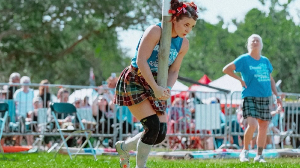 Athlete in a kilt prepares to toss a caber at the Savannah Scottish Games and Celtic Festival.