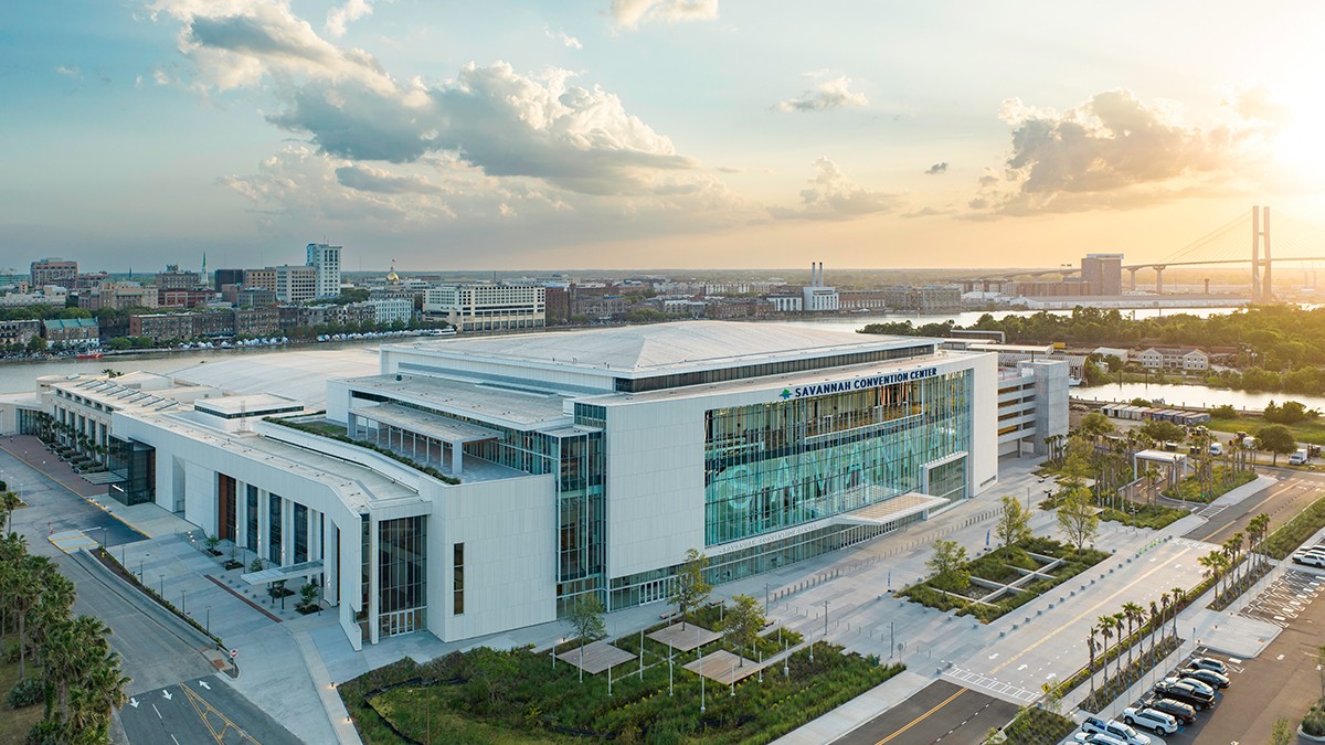 Aerial view of the Savannah Convention Center along the Savannah River at sunset, with the Talmadge Memorial Bridge and downtown skyline in the background.