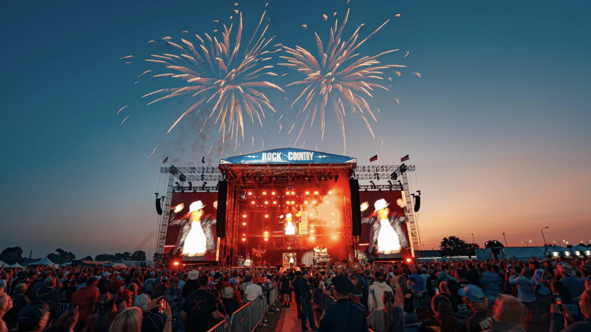 A massive crowd at an outdoor rock and country music festival.