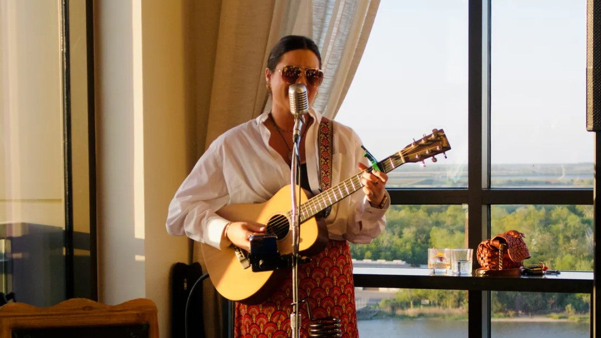 Musician playing guitar and singing at Bar Julian overlooking the Savannah River.