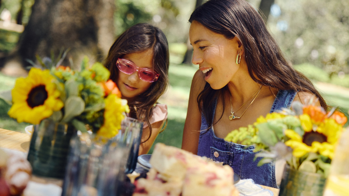 A mother and daughter enjoy a picnic surrounded by flowers and greenery in Savannah.