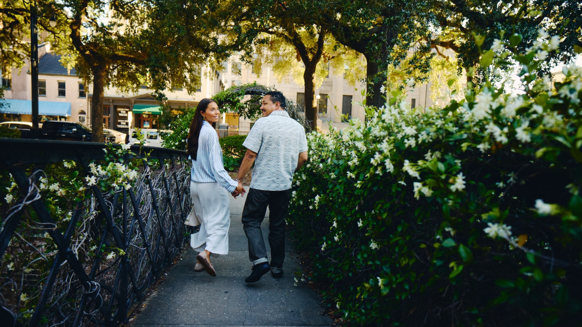 Couple walking hand in hand through Factor’s Walk in Savannah’s Historic District.