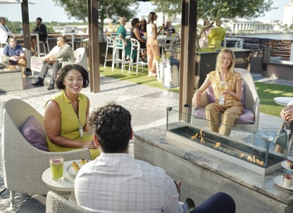 group chatting on rooftop overlooking river