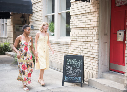Two friends walking towards a vintage shop.
