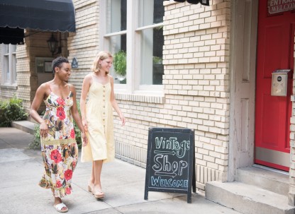 Two friends walking towards a vintage shop.