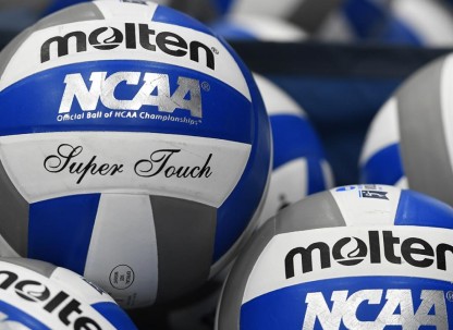 Numerous volleyballs piled together.
