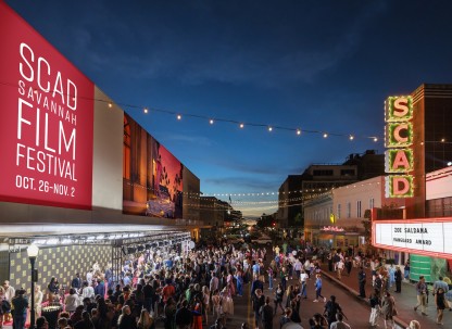 A large crowd gathered outside of a theatre for a film festival.