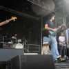 Musicians onstage singing and playing guitar.