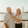 A couple posing for a photo on the outdoor deck of a riverboat.