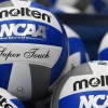 Numerous volleyballs piled together.