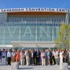 A large group posing for a photo at the front entrance of the Savannah Convention Center.