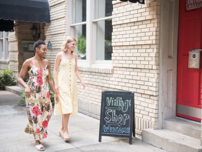 Two friends walking towards a vintage shop.