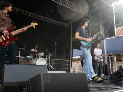 Musicians onstage singing and playing guitar.