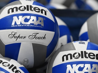 Numerous volleyballs piled together.