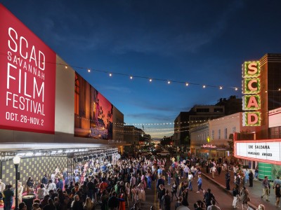 A large crowd gathered outside of a theatre for a film festival.