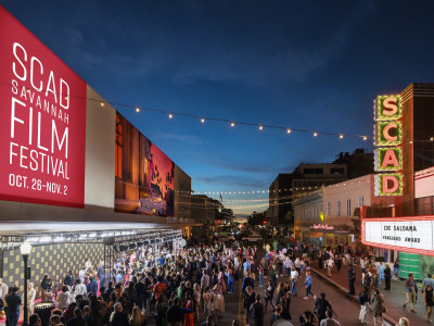 A large crowd gathered outside of a theatre for a film festival.